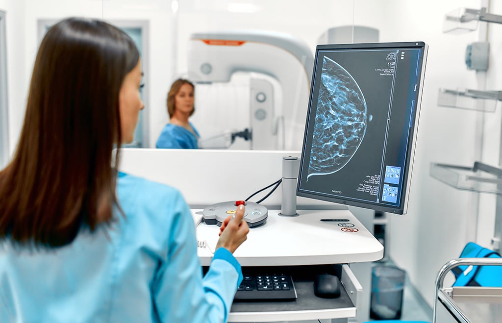 Mammography Technologist Viewing Breast Image Of Female Patient