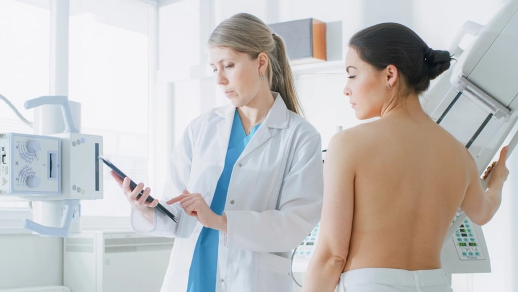 Mammography Technologist Consulting With Woman Before 3D Mammogram
